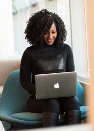 A girl wearing a black dress is happily working with MyBizzHive’s CRM software