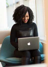 Manage bookings A girl wearing a black dress is happily working with MyBizzHive’s CRM software